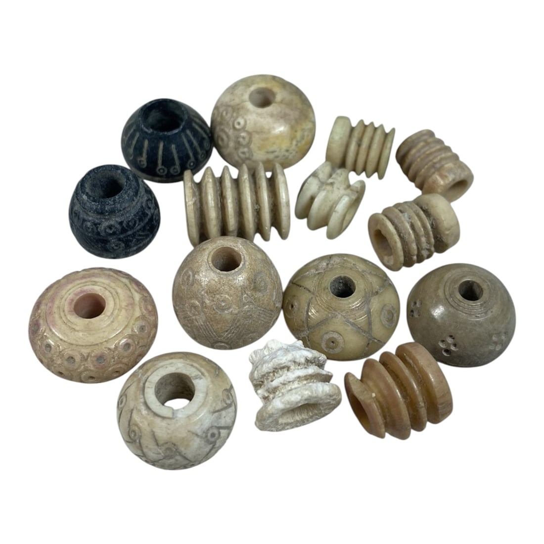 A Lot of 15 Ancient Silk Road Bone Spindle Whorls, 58AB: The group comprises 15 ancient bone spindle whorls, exhibiting natural aged tones including cream, beige, black, and light brown with traces of pigment and surface patina consistent with artifacts fro