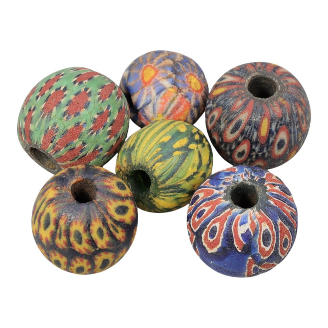 Lot of 6 Ancient to Antique Polychrome Glass Beads, Circa 1st Millennium BCE to Islamic Period, 72AD: Comprising six beads ranging from 1.5 cm (5/8 in.) to 2 cm (3/4 in.), these pieces showcase vibrant polychrome glasswork typical of ancient beadmaking traditions. The beads display a rich variety of d