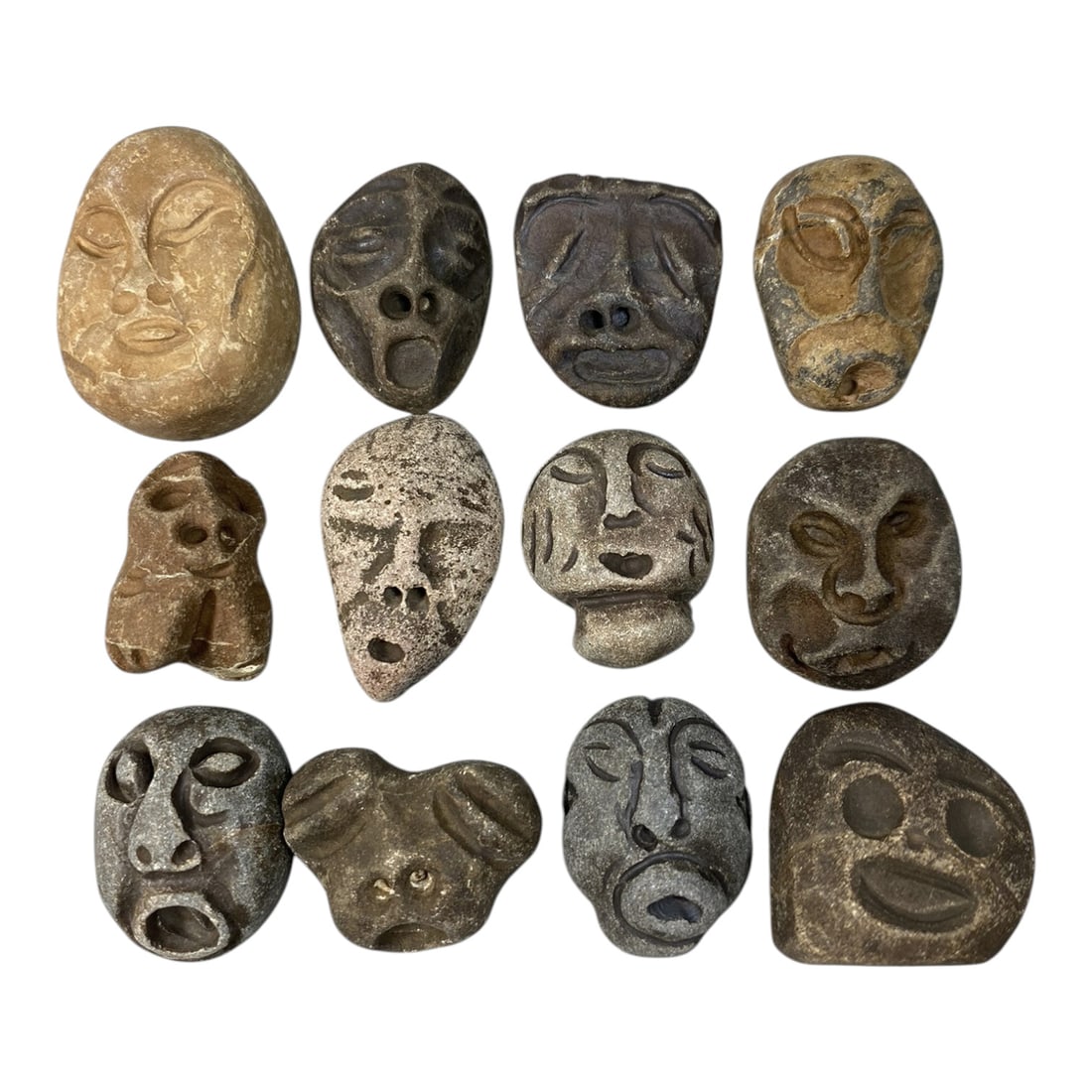 Lot of 12 Ancient Medieval Stone Maskette Amulets, 81AG: A collection of 12 hand-carved stone maskette amulets, attributed to the medieval period, likely from the Mediterranean or Near Eastern regions. Crafted from natural stone in varied earthy tones, incl