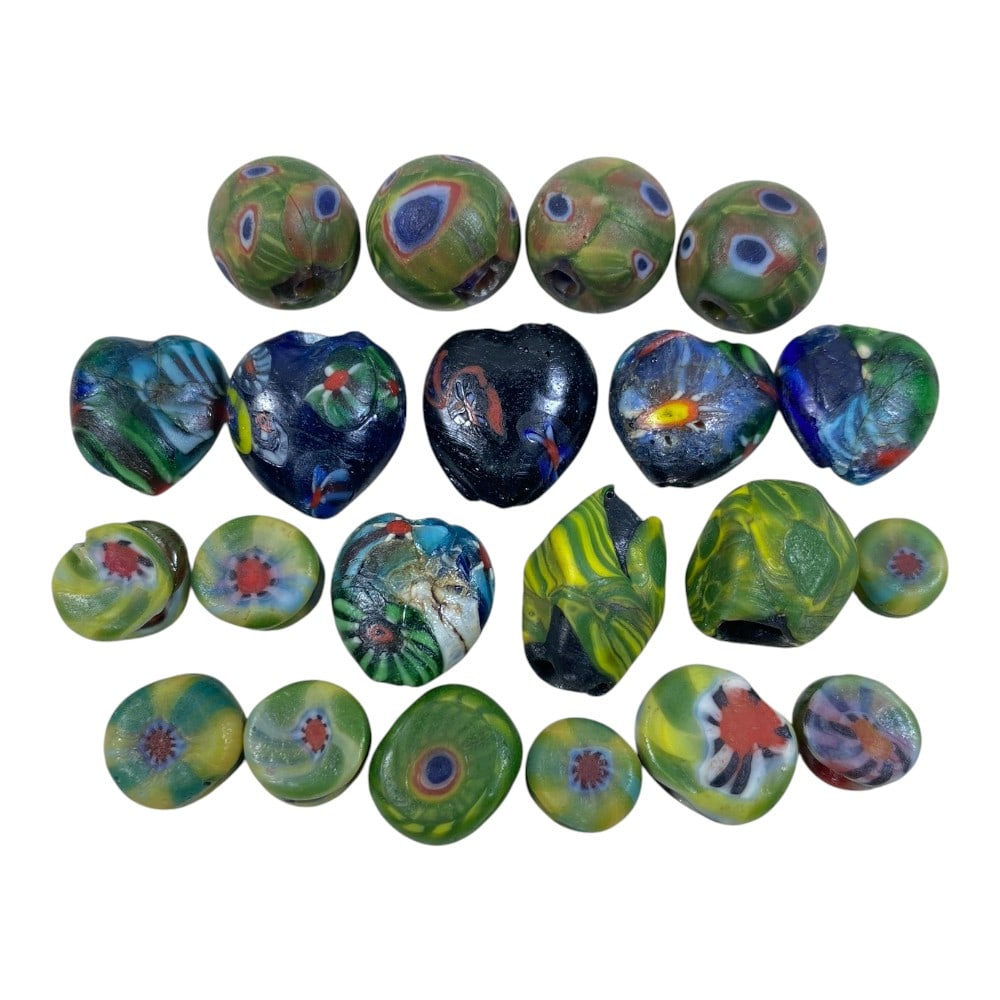 A Lot of 21 Vintage Artisan Glass Beads, 90AA: This eclectic collection features 21 handcrafted vintage glass beads, showcasing a variety of artisanal techniques. The set includes round eye beads, heart-shaped millefiori beads, and flat floral-pat