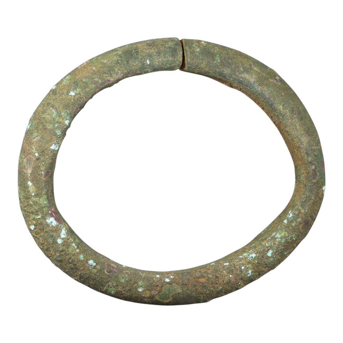 Ancient Bronze Bracelet - Roman Split Bangle, 39BN: A near-continuous bracelet crafted from cast bronze, with a rounded cross-section and a small opening at the top. The simple form is characteristic of utilitarian Roman provincial jewelry, designed fo