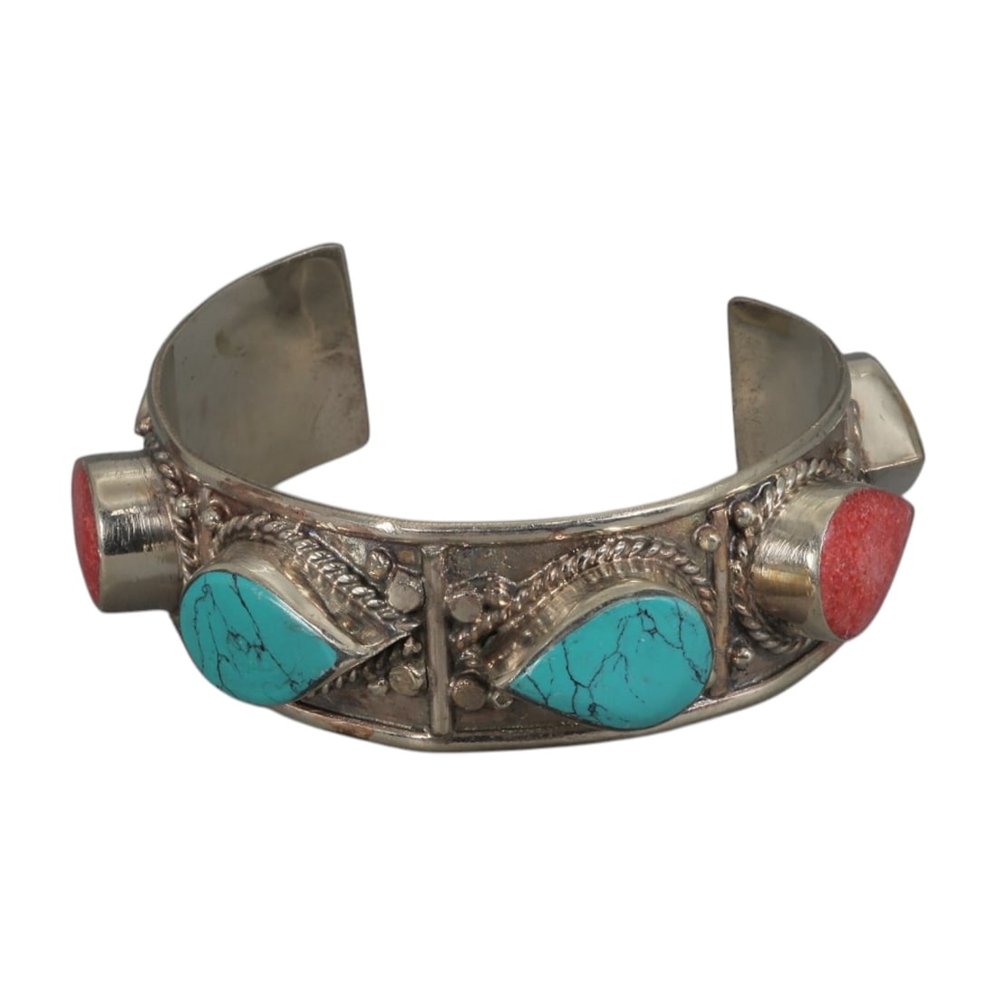 A Vintage Himalayan Silver-Plated Turquoise and Coral Cuff Bracelet, 68AH: A handcrafted vintage cuff bracelet, measuring approximately 6 cm in width, showcasing traditional Himalayan jewelry design. The piece features a silver-plated metal base, with two teardrop-shaped tur