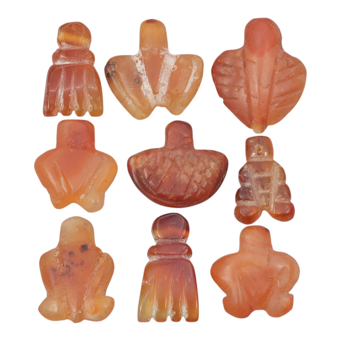 Lot of 9 Ancient Coptic Egyptian Carnelian Amulets, Circa Roman to Coptic Era, 70WT: Carved from carnelian, the group consists of nine distinct amulets of varied forms. The set includes stylized representations such as hand-shaped pendants, fly-shaped amulets, frog-shaped figures, geo
