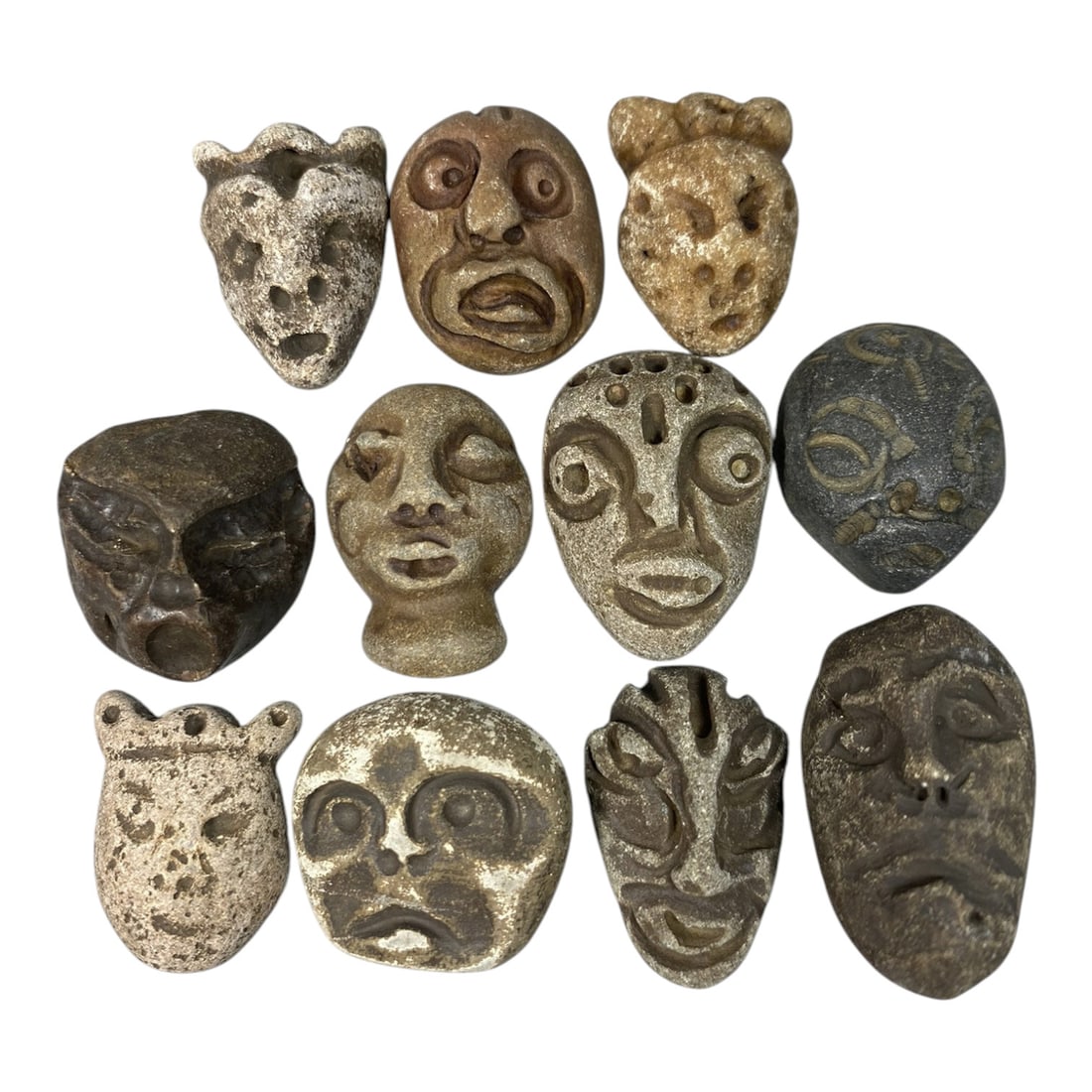 Lot of 11 Ancient Medieval Stone Maskette Amulets, 78AG: A collection of 11 hand-carved stone maskette amulets, attributed to the medieval period, likely from the Mediterranean or Near Eastern regions. Crafted from natural stone in varied earthy tones, incl