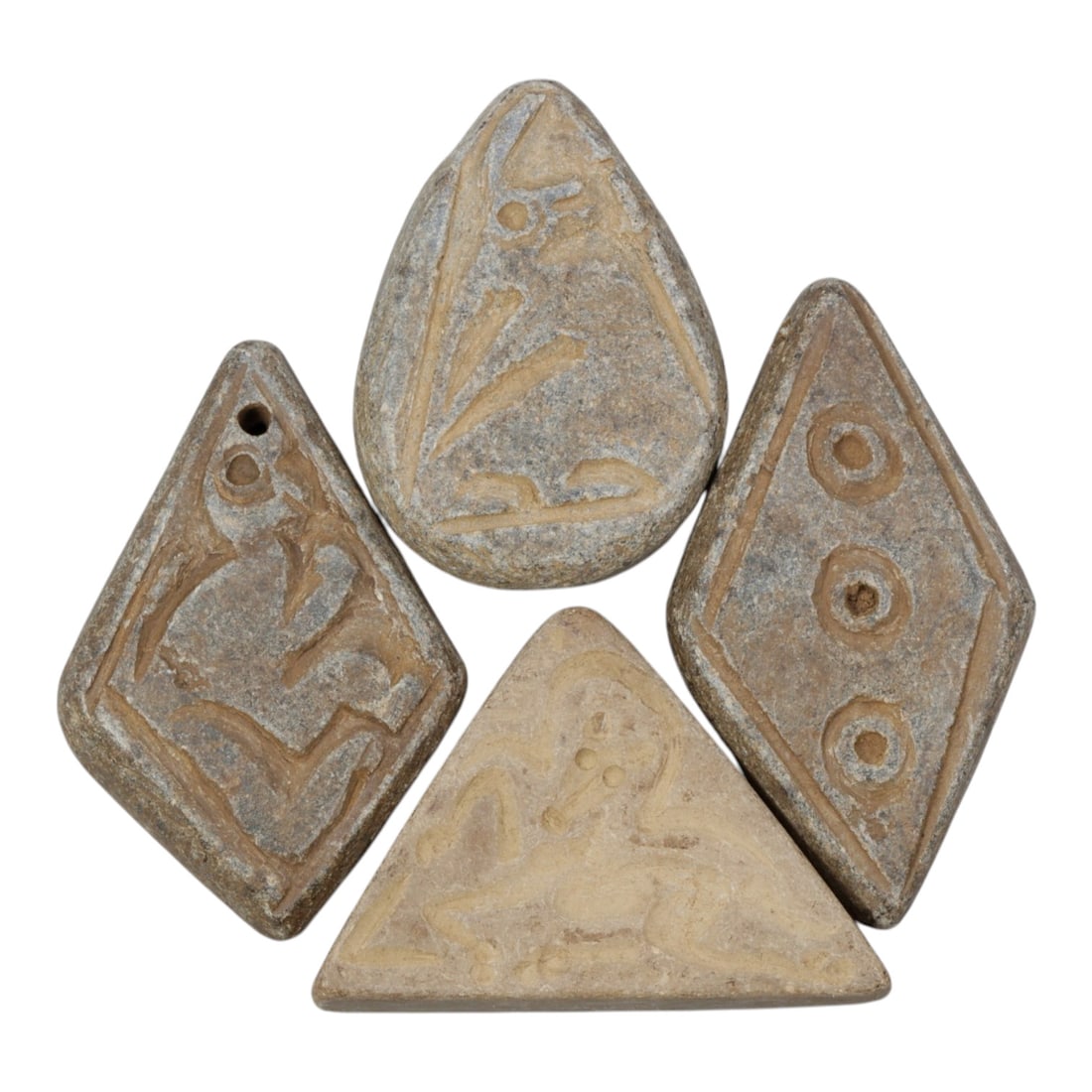 Lot of 4 Ancient Near Eastern Schist Amulets, 82WP: A collection of four ancient Near Eastern amulets, carved from grey schist stone in varied geometric forms: diamond, teardrop, triangular, and lozenge shapes. Each piece is engraved with distinct moti