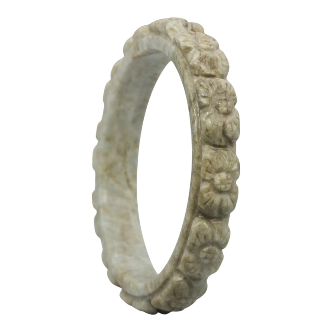 A Chinese Carved Jadeite Jade Bangle Bracelet, 20th Century, 77ZL: A fine jadeite bangle of flattened circular form, masterfully carved in relief with a continuous band of chrysanthemum blossoms. The stone exhibits a pale milky-green base, accented by subtle brownish