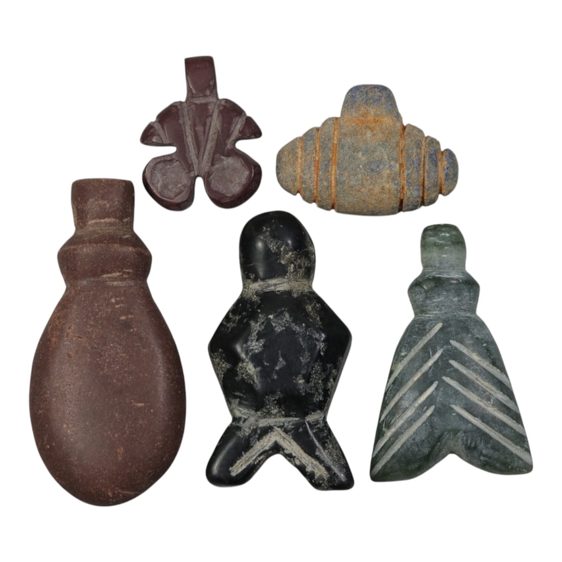 Lot of 5 Ancient Coptic Egyptian Stone Amulets, Circa Roman to Coptic Era, 82WT: Carved from various stones, including reddish-brown, grey, black, and green varieties, the group consists of five distinct amulets. The set includes a stylized fly-shaped pendant, a segmented geometri