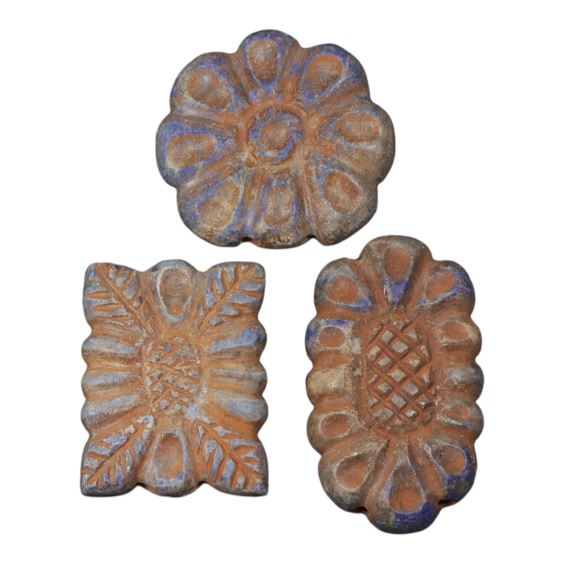 Lot of 3 Ancient Achaemenid Lapis Lazuli Floral Beads, Circa 5th-4th Century BCE, 96AD: Comprising three lapis lazuli beads with floral and geometric relief decoration. The circular example features a radiating rosette design with central boss and petal-shaped recesses. The rectangular e