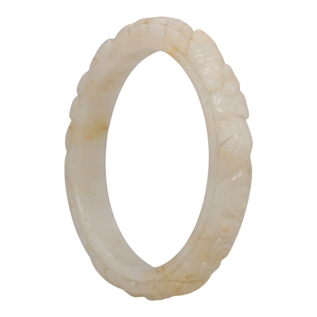 A Chinese Carved Jadeite Jade Bangle Bracelet, 20th Century, 44ZL: A fine jadeite bangle of flattened circular form, masterfully carved in relief with a continuous band of floral blossoms and scrolling foliate motifs. The stone exhibits a creamy white base, accented 
