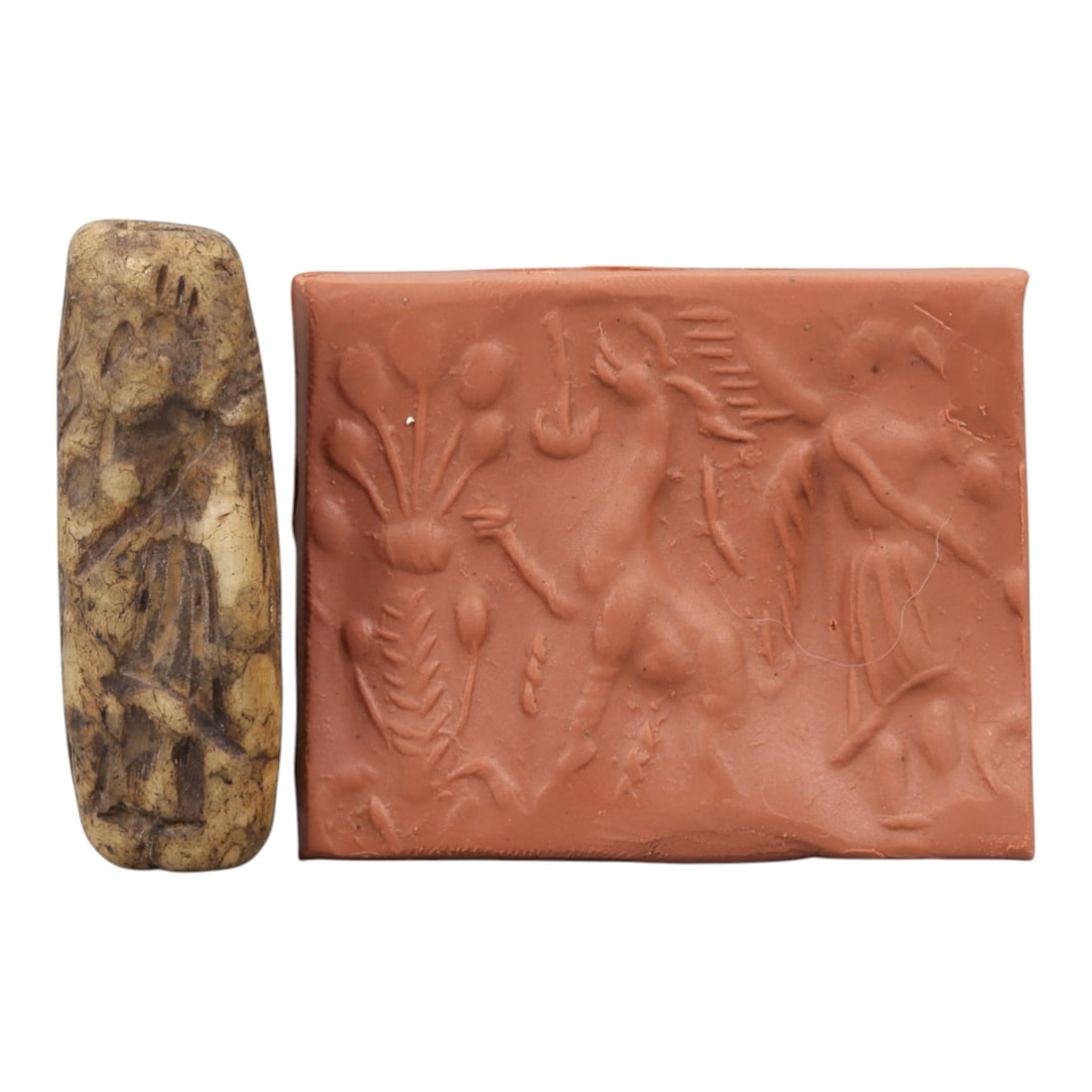 Ancient Steatite Cylinder Seal - Mesopotamian Mythological & Botanical Scene, 77AN: Carved from dense steatite, this ancient Mesopotamian cylinder seal features a detailed linear relief composition of a winged humanoid figure, caprine creature, and botanical motifs, executed in the c
