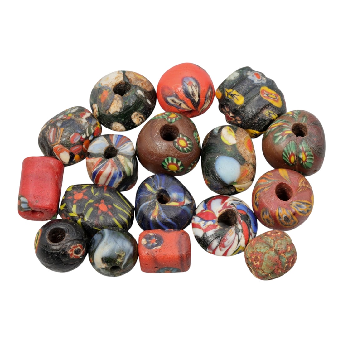 A Lot of 17 Antique/ Vintage Artisan Glass Trade Beads, 25WM: A group of 17 glass beads, each varying in form, colour, and decorative style. The beads include round, barrel, and cylindrical forms, all with central perforations for threading. Decoration technique