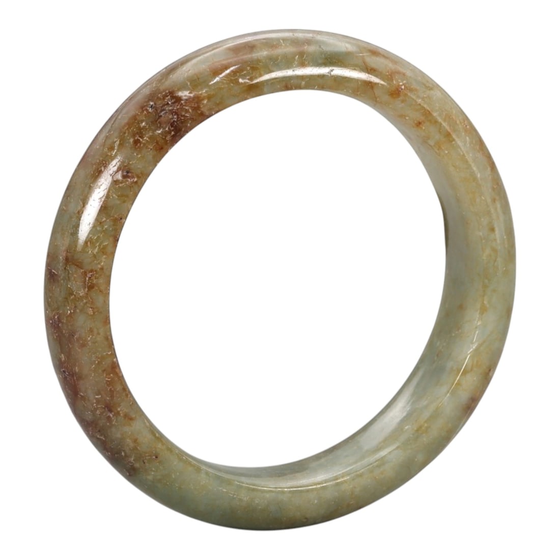 A Chinese Jadeite Jade Bangle Bracelet, 20th Century, 98ZK: Carved from jadeite jade with a transitional palette of pale green at the base grading to rich russet and amber-hued inclusions concentrated on the upper portion, the bangle is formed as a continuous 