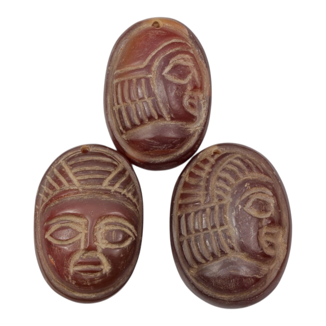 Lot of 3 Ancient Coptic Egyptian Carnelian Face Beads, Circa Roman to Coptic Era, 52WM: A curated lot of three ancient Coptic Egyptian-style beads, carved from natural carnelian stone with rich reddish-brown hues and natural patina consistent with age. Each oval bead features incised fac