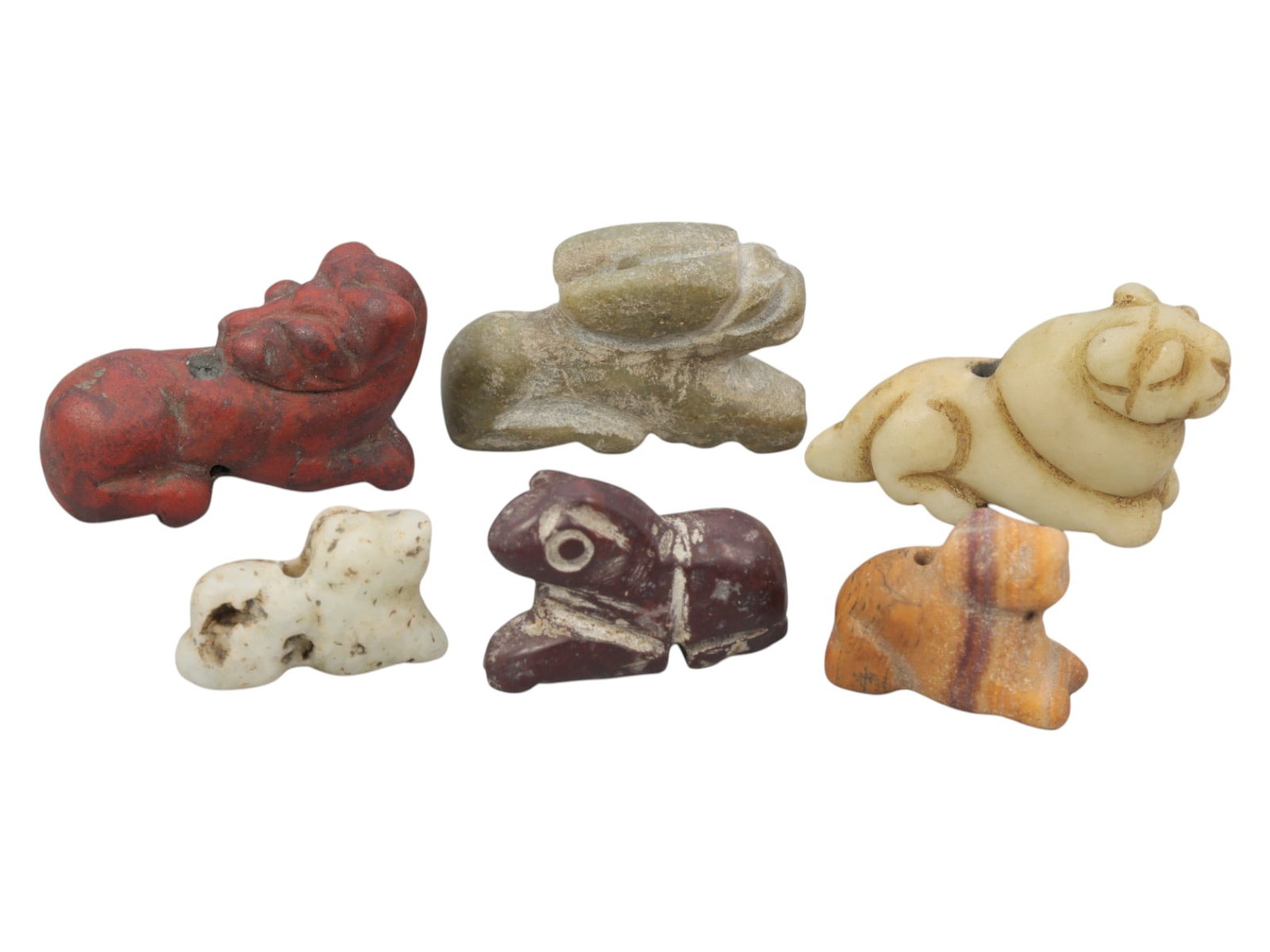 Lot of 6 Ancient Near Eastern Zoomorphic Stone Amulets, c. Iron Age to Sasanian Period, 90WK: A varied collection of six zoomorphic stone amulets from the Ancient Near East, carved from diverse materials including red, green, white, maroon, and banded stone. The set features stylized recumbent