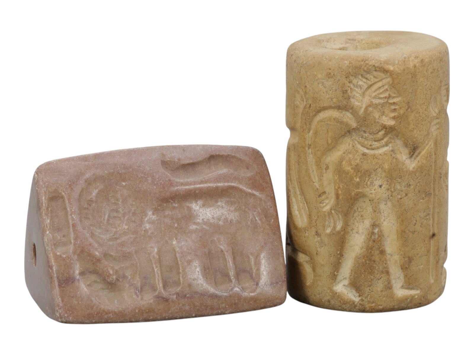 Lot of 2 Ancient Mesopotamian Stone Cylinder and Pyramidal Seals, 79WP: A curated lot of two ancient Mesopotamian-style stone seals, including one cylindrical and one pyramidal stamp seal, both with natural patination and wear consistent with age. The cylindrical seal fea