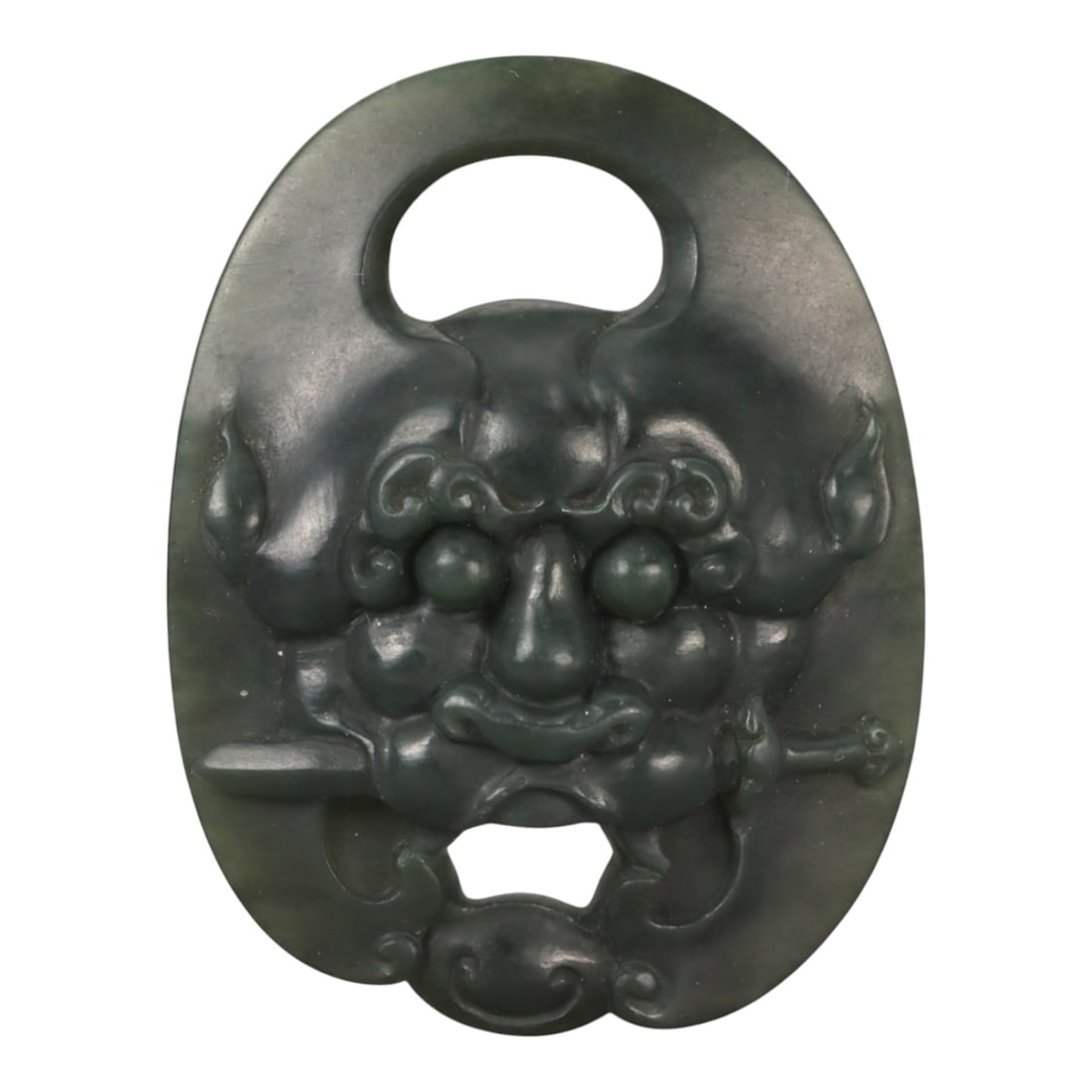 A Chinese Nephrite Jade Mask Pendant, 20th Century, 98FB: Carved from dark green nephrite jade with subtle tonal variation and a softly polished surface, the pendant is of oval form and worked in high relief with a stylized mask motif. The face is symmetrica