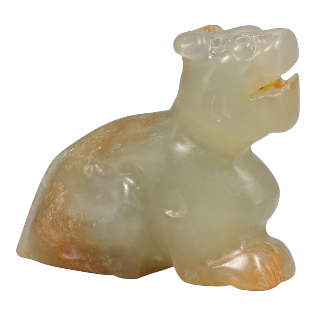 A Chinese Jade Mythical Beast Effigy, 20th Century, 44YC: The figure is carved from jade of pale celadon tone with areas of russet and honey-colored inclusions, the stone displaying soft translucency and natural mottling. It is worked in the round as a seate