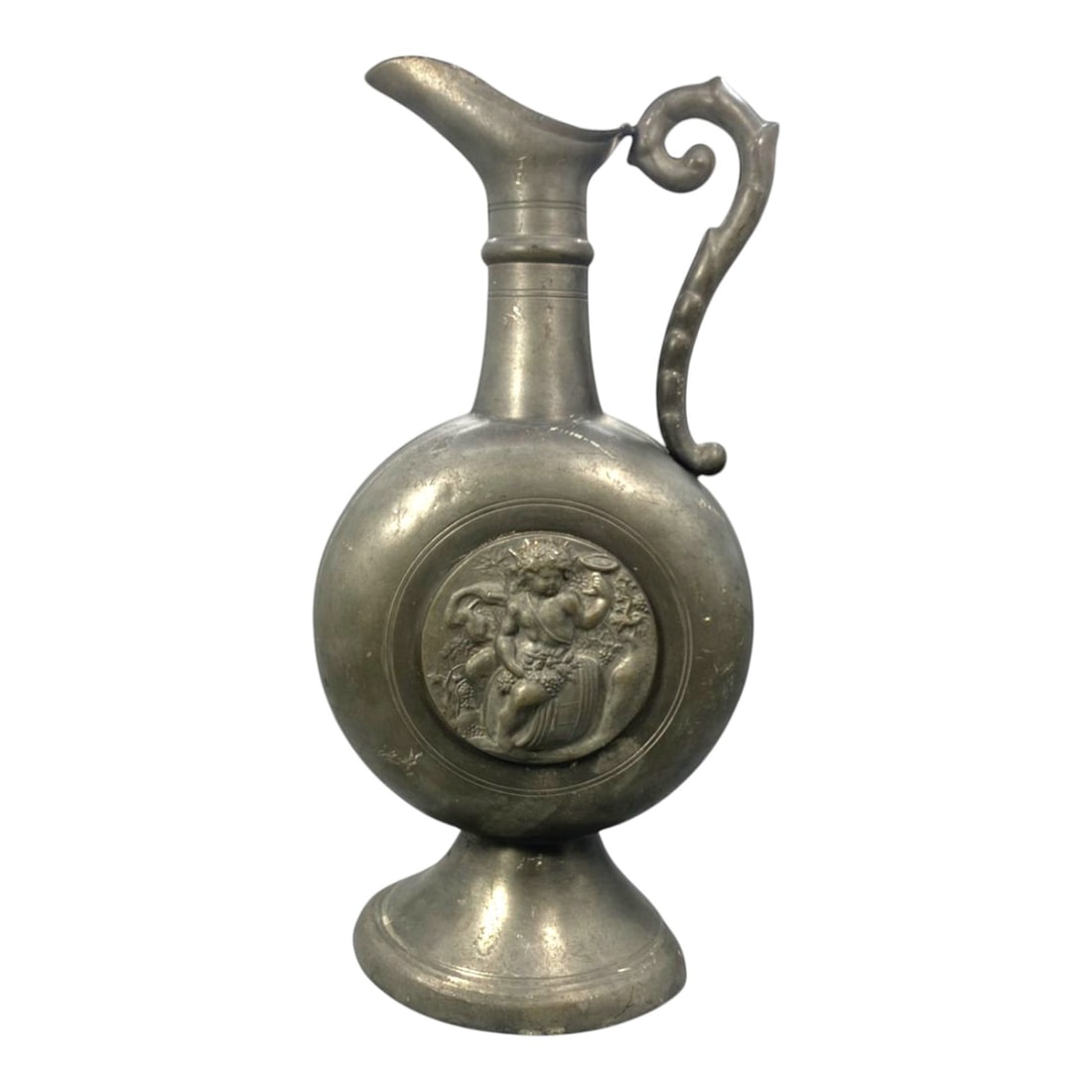 A Swiss Pewter Pitcher by Guggisberg Lugano, 20th Century, 55FK: The pitcher is formed in pewter with a globular body raised on a spreading circular foot, supporting a narrow cylindrical neck and a flaring pouring spout. A curved handle with a scrolling terminal is