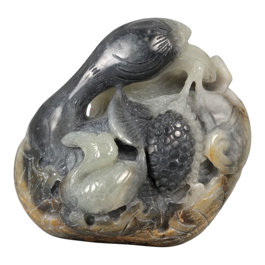 A Chinese Hetian Nephrite Jade Carving of Birds and Grapes, 20th Century, 22FD: Carved from a naturally variegated pebble of Hetian nephrite jade, the sculpture is worked in high relief and openwork to depict a lively scene of birds amidst fruiting vines. Two birds, their bodies 