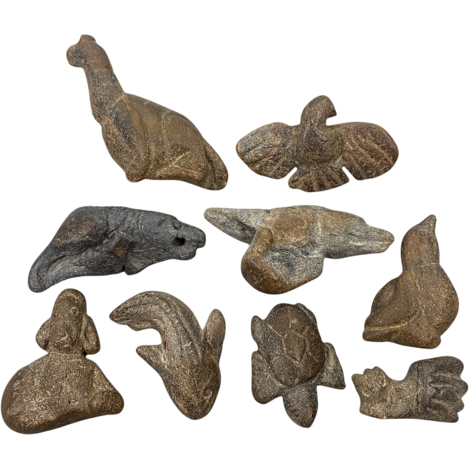 Lot of 9 Medieval Tribal Stone Carvings, Mediterranean Region, 45XJ: A collection of nine hand-carved stone figurines attributed to medieval tribal cultures of the Mediterranean region. Crafted from dark, coarse-grained stone, the carvings have a weathered, earthy pati