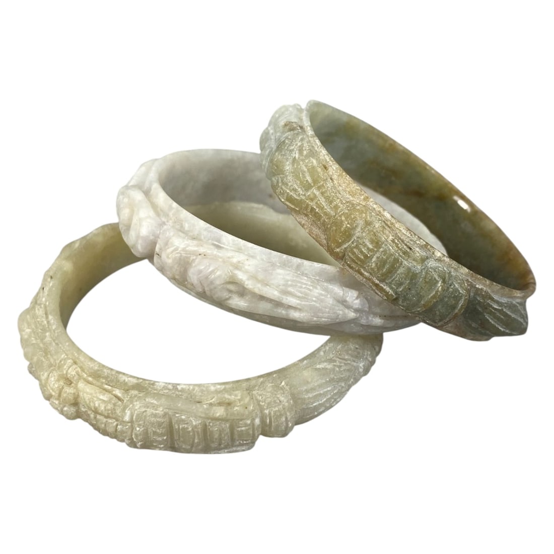 Lot of 3 Chinese Carved Jadeite Jade Bracelets (Bangles), 87AC: Each bracelet is carved from jadeite with varied natural coloration and inclusions, including pale off-white with faint lavender undertones, creamy beige, and mottled grey-green with brownish hues. Th