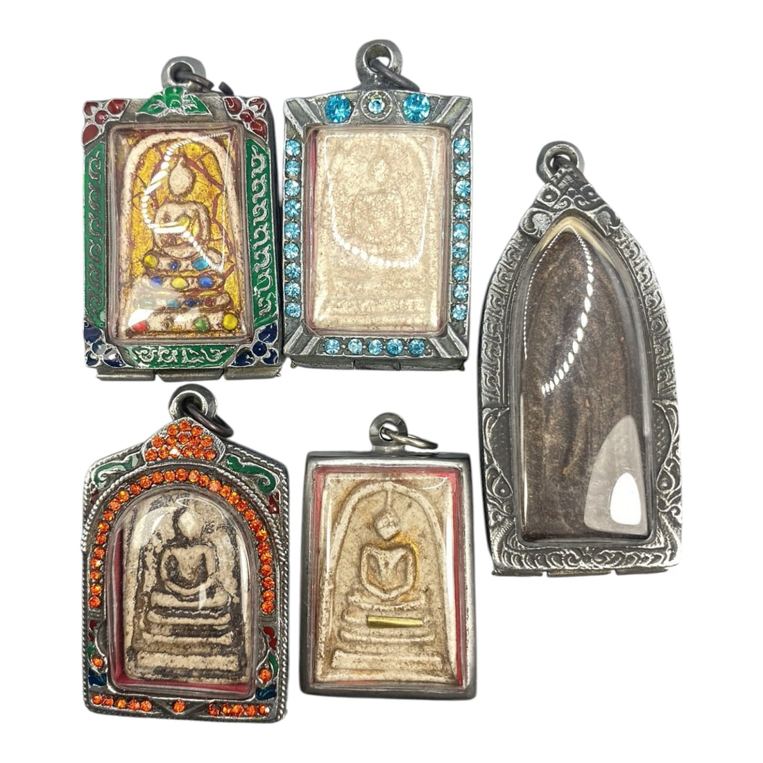 A Lot of 5 Vintage Thai Buddhist Amulets with Enamel and Jewel Accents, 17WT: A curated lot of five vintage Thai Buddhist amulets, each encased in ornate metal frames with enamel detailing and jewel accents. The amulets feature traditional seated Buddha iconography, with varyin