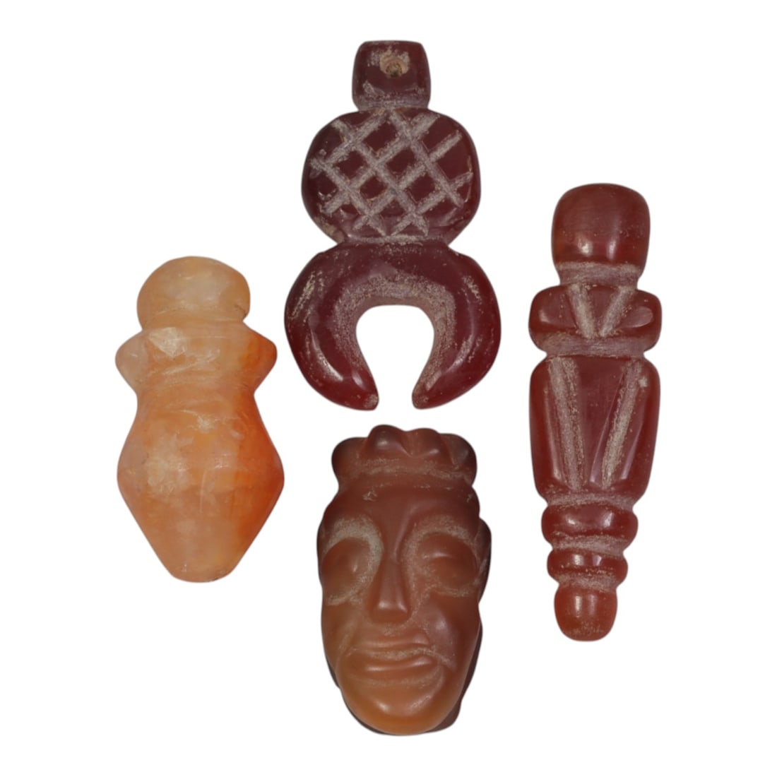 Lot of 4 Ancient Coptic Egyptian Carnelian Amulets, c. Roman Period to Coptic Era, 27WL: Carved from warm, translucent carnelian with natural orange-red hues and subtle weathering, this set includes four distinct forms: a stylized column pendant, a zoomorphic animal head, a bud-shaped cha