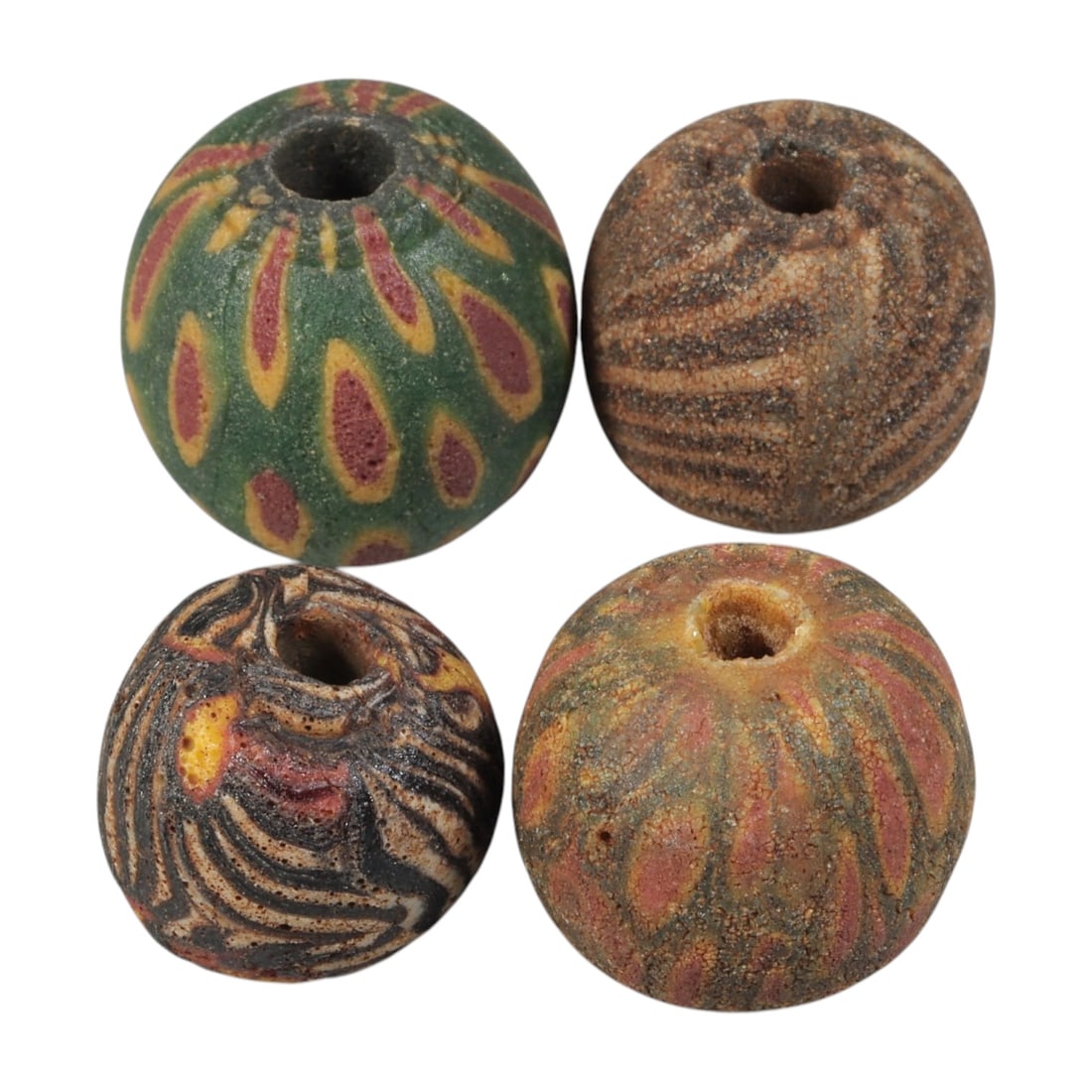 Lot of 4 Ancient to Antique Polychrome Glass Beads, 1st Mil BCE to Islamic Period, 32WM: A group of four spherical polychrome glass beads, each with a central perforation. The beads feature varied decorative styles, including eye motifs, feather patterns, and marbled swirl designs in gree