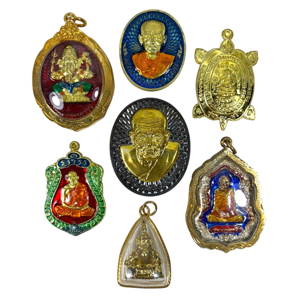 A Lot of 6 Vintage Gilt Thai Buddhist Amulets with Enamel Accents, 21AA: Comprising six pendants ranging from 3.5 to 4.5 cm in height. The collection features a diverse array of sacred imagery, including revered monastic portraits, a turtle-shaped prosperity amulet, and a 