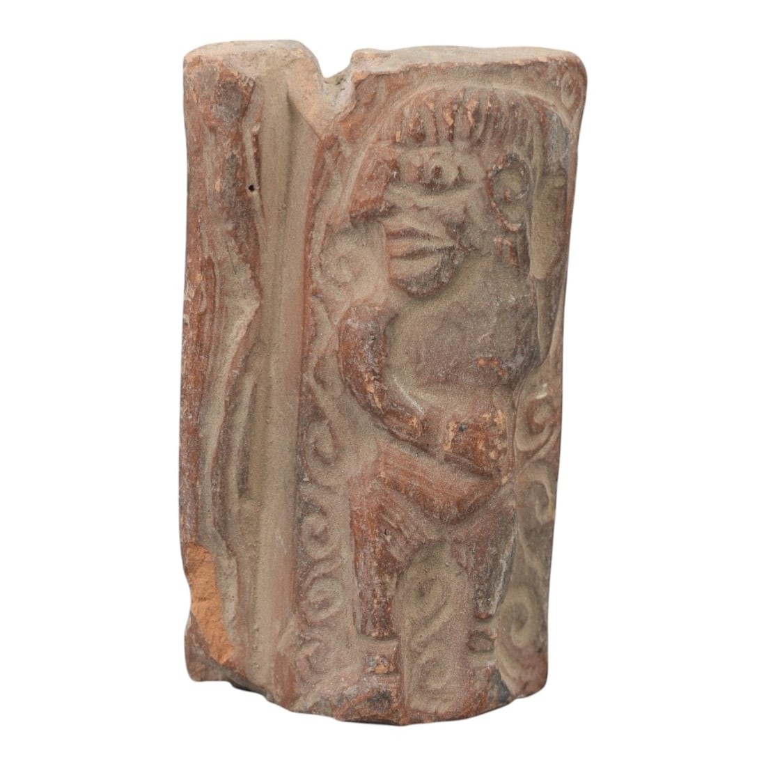 A Near Eastern Terracotta Plaque, 3rd-2nd Millennium BCE, 81FL: Molded from reddish-brown terracotta with natural surface patination and visible edge losses, the object is formed as a rectangular plaque fragment. The relief depicts a standing humanoid figure with 