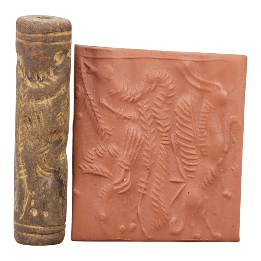 Ancient Steatite Cylinder Seal - Mesopotamian Mythical Creature Scene, 69AN: Carved from dense steatite, this ancient Mesopotamian cylinder seal features a detailed linear relief composition of winged mythical creatures interwoven with botanical motifs, executed in the charact
