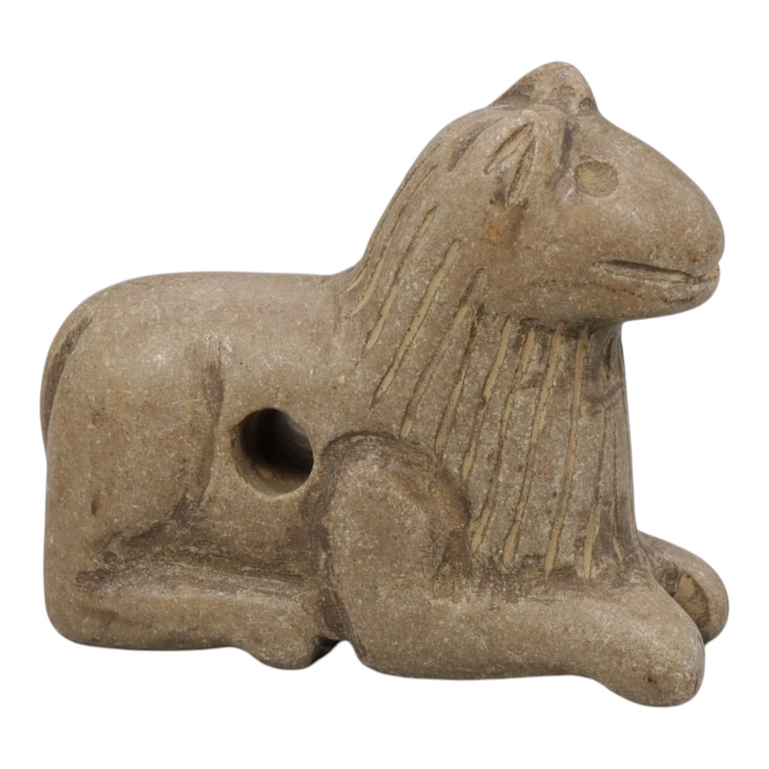 Ancient Near Eastern Style Stone Recumbent Feline Amulet, 90WM: A single ancient Near Eastern-style stone amulet, carved in the form of a recumbent feline (likely a lion or similar big cat). The piece features stylized incised lines representing the mane, simple c
