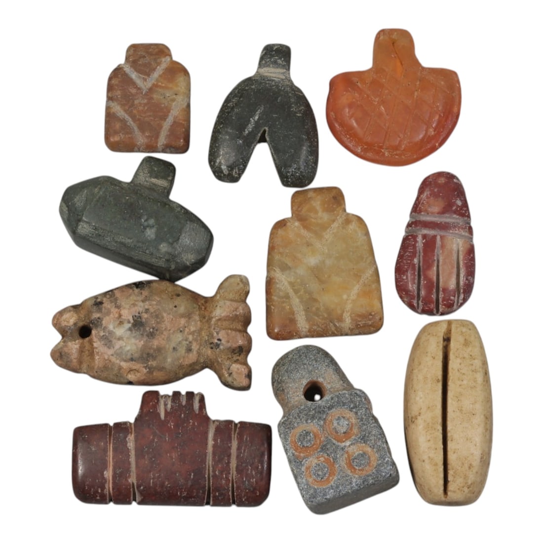 Lot of 10 Ancient Coptic Egyptian Multi-Stone Amulets, Circa Roman to Coptic Era, 86AH: Carved from diverse materials including yellowish marble, dark green serpentine, orange carnelian, pinkish speckled stone, reddish-brown, grey stone, and light beige varieties, the group consists of t