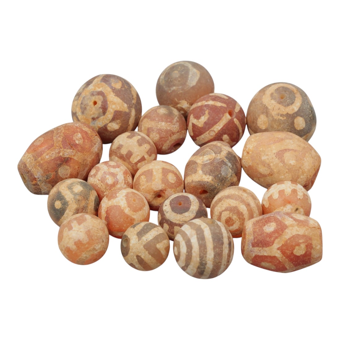 Lot of 20 Ancient Etched Carnelian Beads, Gandhara Period, 22WM: A group of 20 ancient etched carnelian beads from the Gandhara period. The beads are spherical, oval, and barrel-shaped, crafted from reddish-orange, brown, and greyish carnelian. Each bead features i