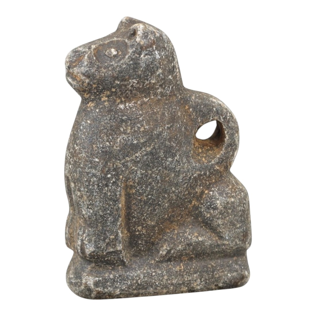 Ancient Stone Zoomorphic Amulet - Near Eastern Animal Figure, 3AM: This amulet is carved from dark speckled stone, depicting a stylized quadrupedal animal in a seated posture, with incised linear detailing defining the facial features, ears, and limbs. The piece refl