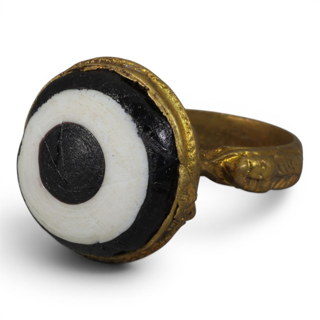 Antique Qajar Dynasty Gilt Evil Eye Ring, US Size 8, 50AJ: A gilt-metal ring of the Qajar period, US ring size 8, featuring a large domed evil-eye glass inlay with a bold concentric black-and-white design (the glass exhibits age-related cracks). The bezel is 