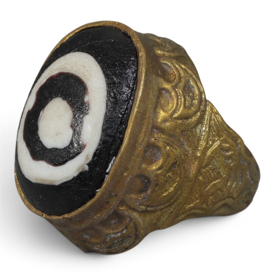 Antique Qajar Dynasty Gilt Evil Eye Ring, US Size 7, 30AJ: A gilt-metal ring of the Qajar period, US ring size 7, featuring a large domed evil-eye glass inlay with a concentric black-and-white design (the glass exhibits age-related cracks). The bezel and wide