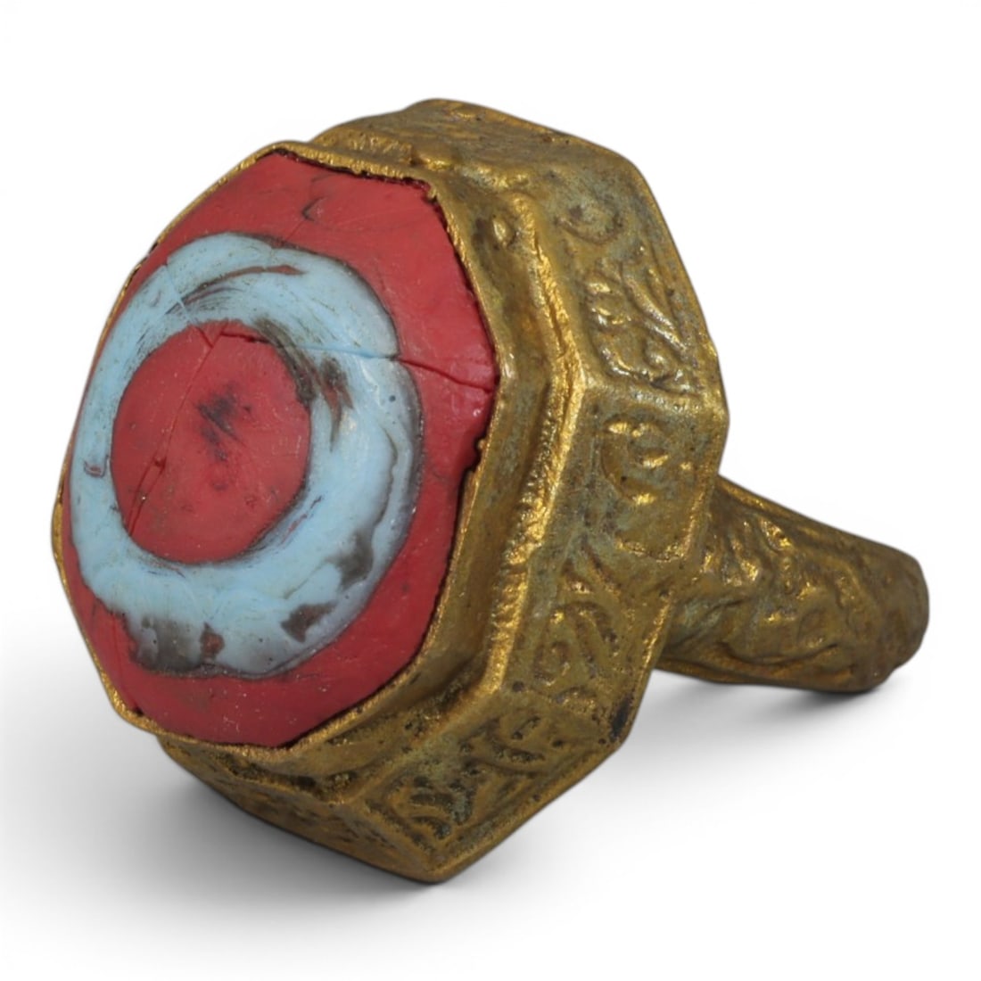 Antique Qajar Dynasty Gilt Evil Eye Ring, US Size 8, 7AJ: A gilt-metal ring of the Qajar period, US ring size 8, featuring a hexagonal evil-eye glass inlay with a vibrant red and light blue concentric design. The bezel and band are adorned with detailed repo