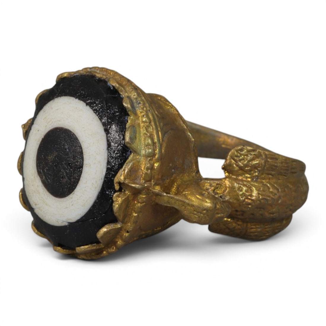 Antique Qajar Dynasty Gilt Evil Eye Ring, US Size 8, 35AJ: A gilt-metal ring of the Qajar period, US ring size 8, featuring a large domed evil-eye glass inlay with a bold concentric black-and-white design (the glass exhibits age-related cracks). The bezel is 
