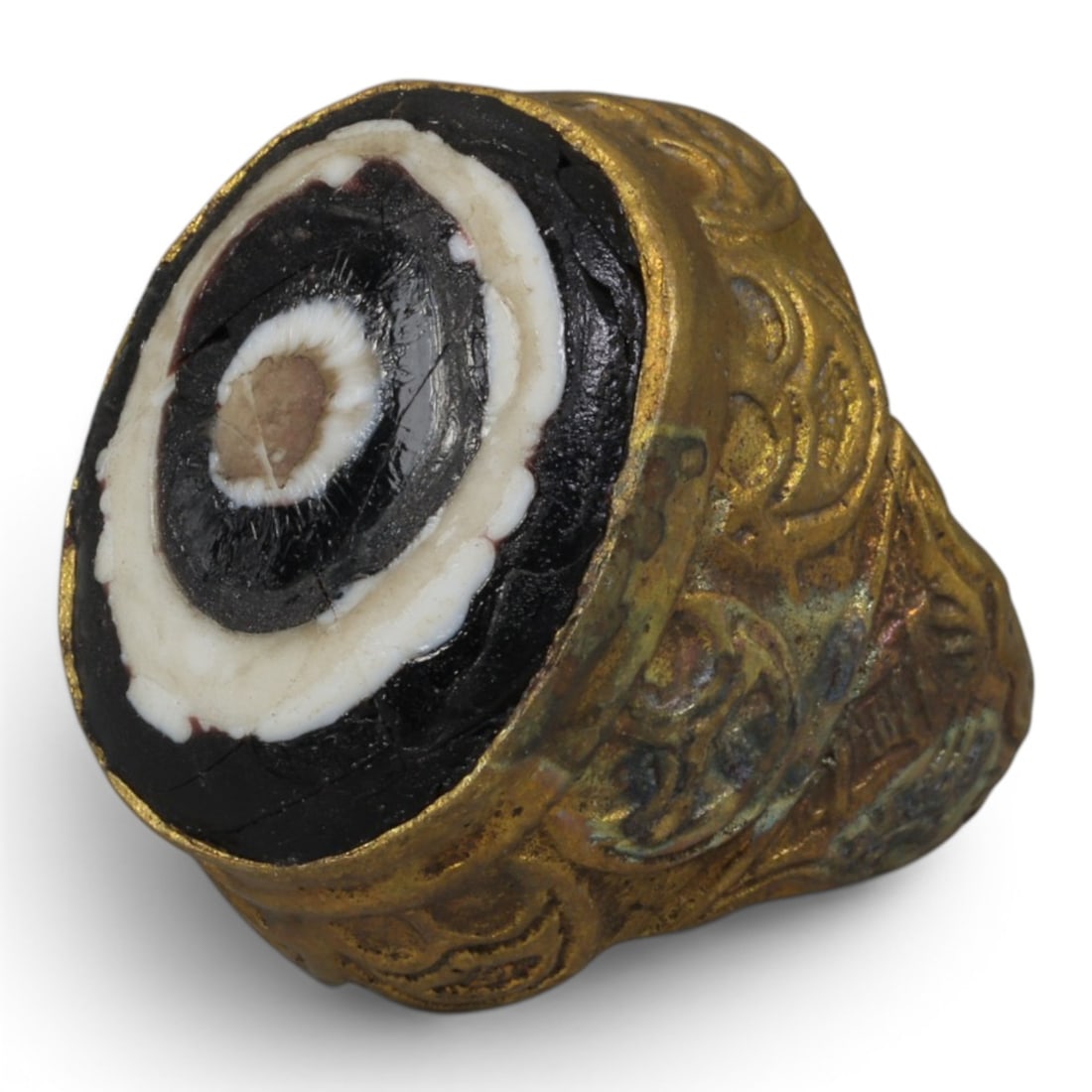 Antique Qajar Dynasty Gilt Evil Eye Ring, US Size 7.5, 28AJ: A gilt-metal ring of the Qajar period, US ring size 7.5, featuring a large domed evil-eye glass inlay with concentric black, white, and brown layers. The central eye motif is set within a richly decor