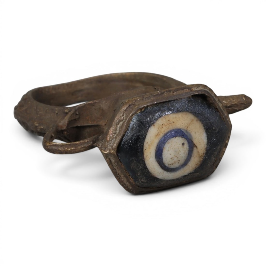 Antique Qajar Dynasty Bronze Evil Eye Ring, US Size 6.5, 26AJ: A bronze ring of the Qajar period, US ring size 6.5, featuring a hexagonal evil-eye glass inlay with a striking concentric design in dark blue, white, and blue. The glass exhibits age-related patina a