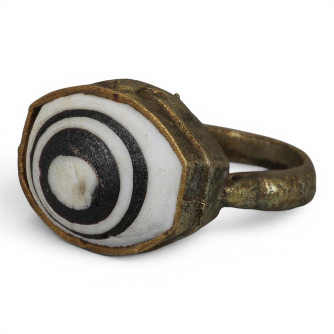 Antique Qajar Dynasty Gilt Evil Eye Ring, US Size 9, 42AJ: A gilt-metal ring of the Qajar period, US ring size 9, featuring an oval evil-eye glass inlay with a bold concentric black-and-white design (the glass exhibits age-related cracks). The bezel and band 