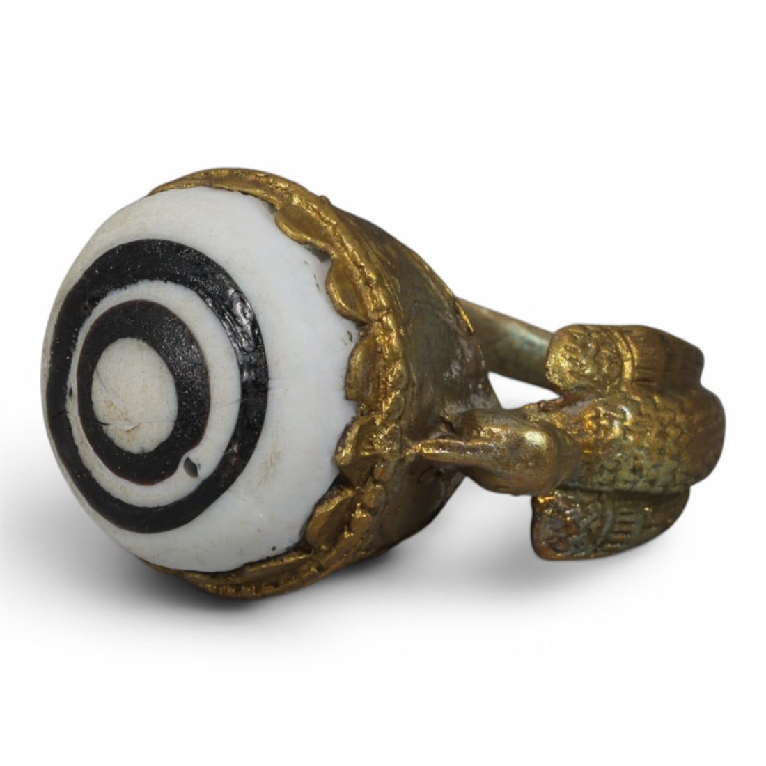 Antique Qajar Dynasty Gilt Evil Eye Ring, US Size 8.5, 6AJ: A gilt-metal ring of the Qajar period, US ring size 8.5, featuring a large domed evil-eye glass inlay with a bold concentric black-and-white design. The bezel is adorned with a decorative scalloped ed