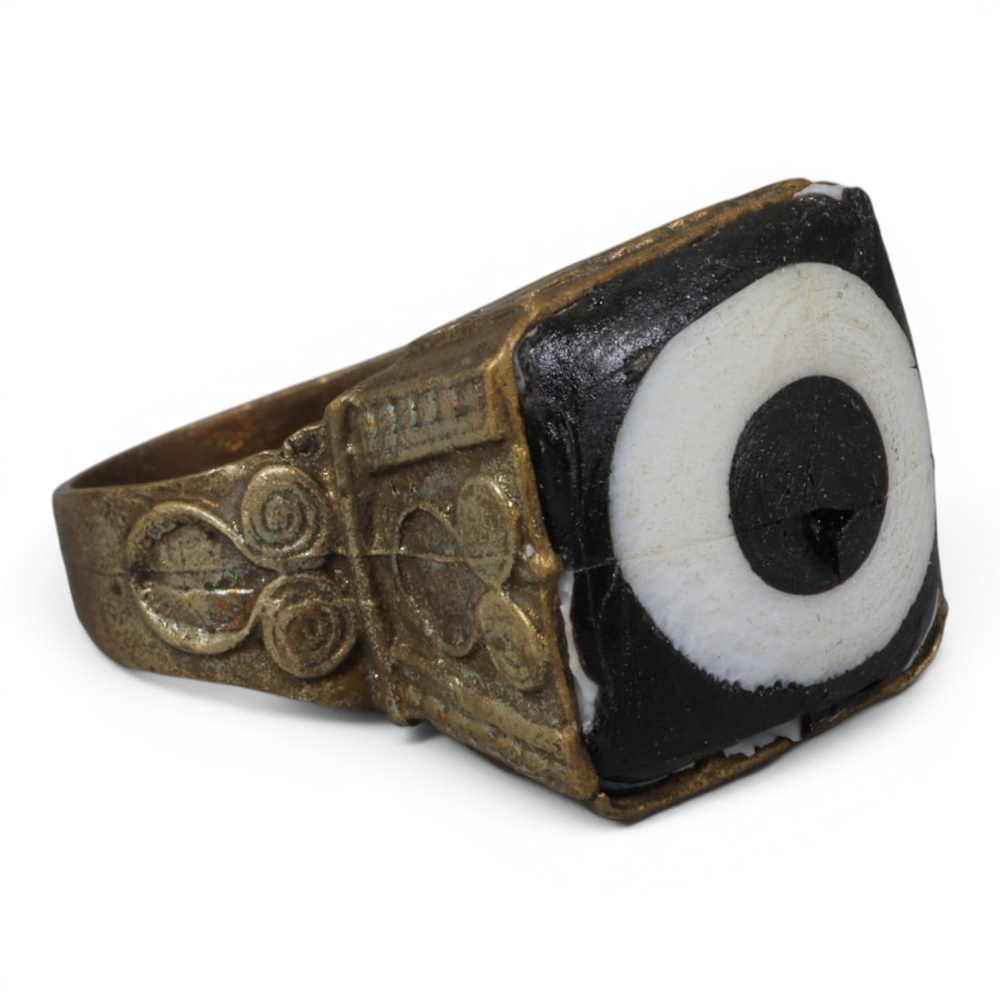 Antique Qajar Dynasty Gilt Evil Eye Ring, US Size 9.5, 24AJ: A gilt-metal ring of the Qajar period, US ring size 9.5, featuring a square evil-eye glass inlay with a bold concentric black-and-white design (the glass exhibits age-related cracks). The bezel and ba