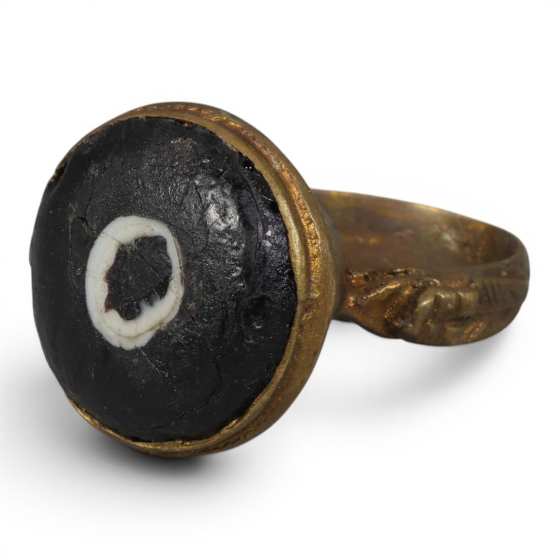 Antique Qajar Dynasty Gilt Evil Eye Ring, US Size 8.5, 45AJ: A gilt-metal ring of the Qajar period, US ring size 8.5, featuring a large domed evil-eye glass inlay with a bold concentric black-and-white design (the glass exhibits age-related cracks). The bezel i
