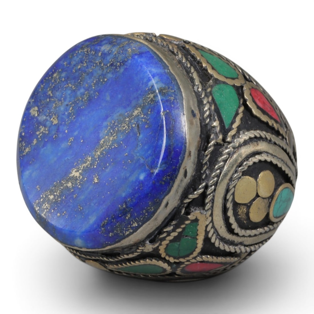 Antique Central Asian Silver and Lapis Lazuli Tribal Ring, 19th-Early 20th Century, 65AJ: The ring is set with a large, flat cabochon lapis lazuli stone, displaying characteristic pyrite inclusions within its deep blue matrix. The silver mount is decorated with pseudo-filigree wirework and