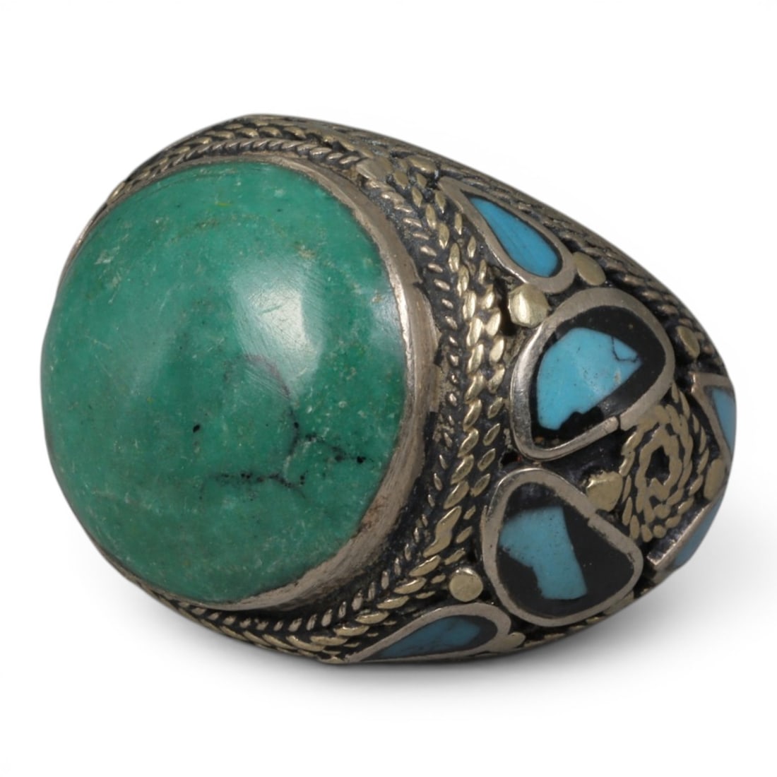 Antique Central Asian Silver and Turquoise Tribal Ring, 19th-Early 20th Century, 59AJ: The ring is set with a large, smooth cabochon turquoise stone, displaying natural matrix inclusions within its green-blue matrix. The silver mount is decorated with pseudo-filigree scale-pattern wirew