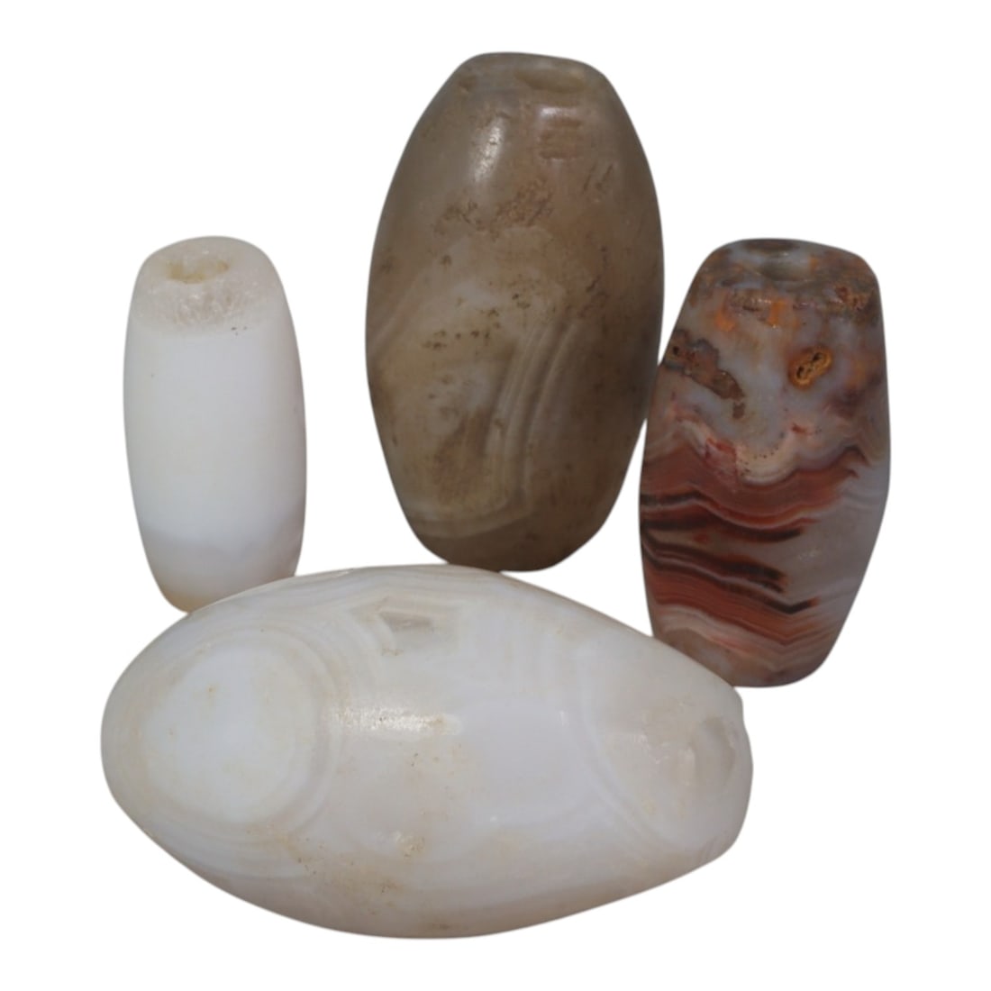 Lot of 4 Antique Central Asian / Himalayan Banded Agate Trade Beads, 49AK: The set includes four barrel-shaped agate beads, each with distinct natural banding and patina: a translucent white bead with subtle concentric patterns, a muted greyish-brown bead with faint striatio