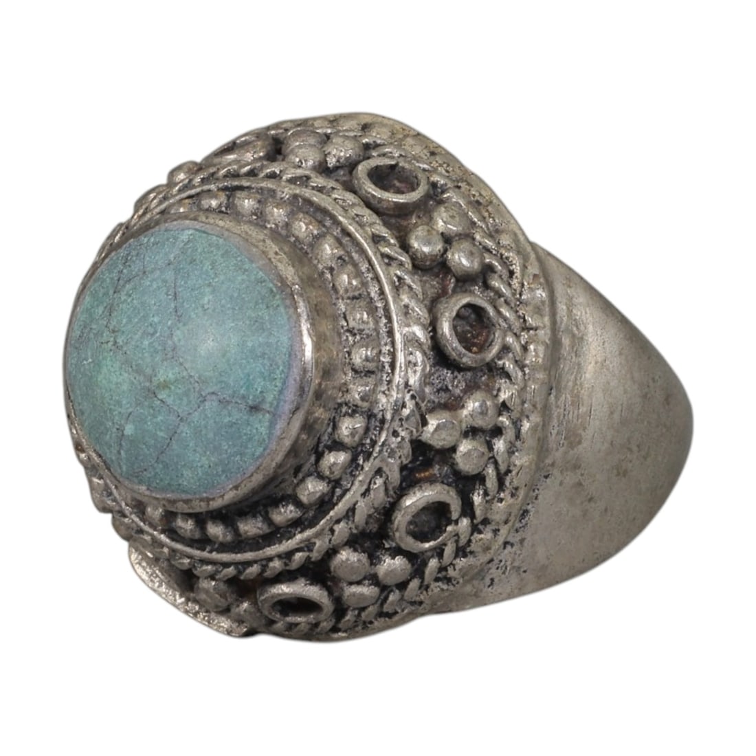A Middle Eastern Silver Plated Turquoise Ring, Late 19th-Early 20th Century, 11AK: The ring is centered with a round cabochon turquoise stone exhibiting natural light blue-green tones and surface veining, set within a domed bezel decorated with beaded granulation, twisted wirework, 