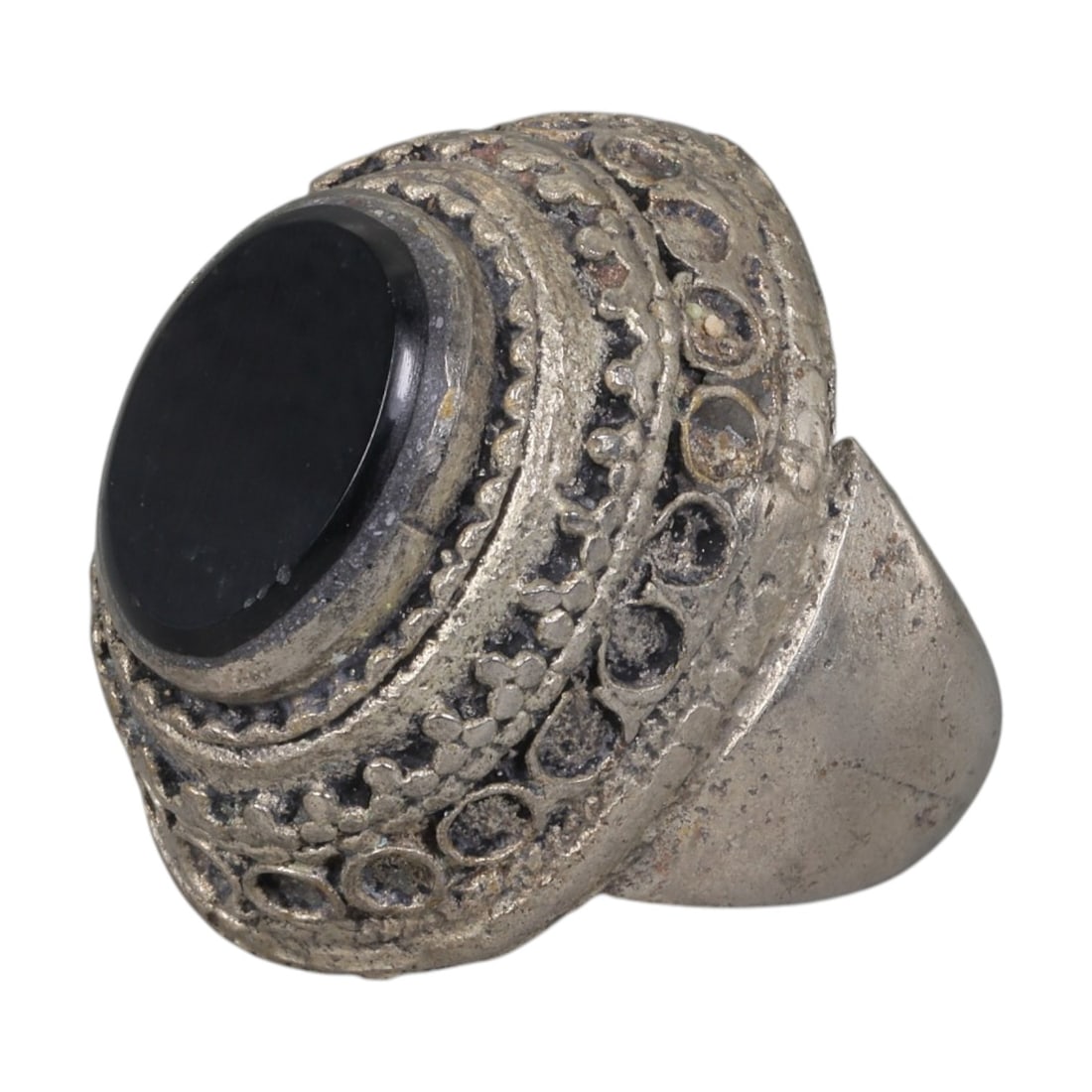 A Middle Eastern Silver Plated Onyx Ring, Late 19th-Early 20th Century, 20AK: The ring is centered with a round cabochon onyx stone, set within a multi-layered bezel featuring raised floral motifs and rows of empty circular settings. The surface displays patina, surface wear, a